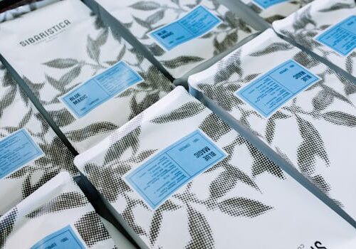 Close-up of branded coffee packages with artistic black and white leaf pattern.