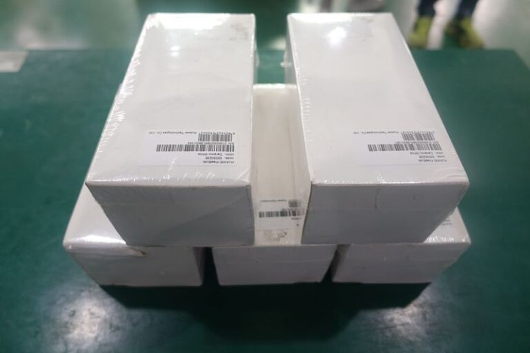 Labeled white folded boxes with automatic labeling machine applied for packaging and logistics carton labeling