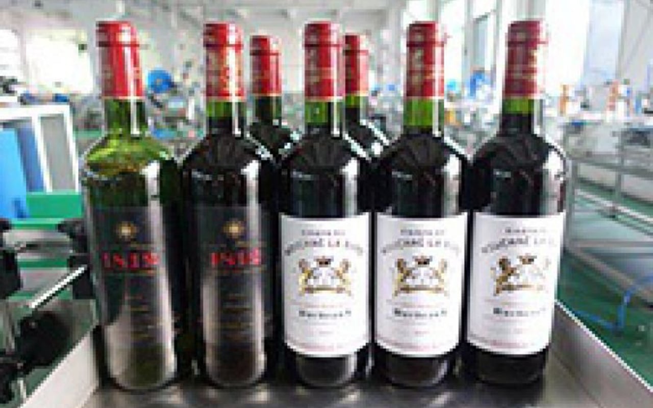 Labeled wine bottles with automatic labeling machine applied for beverage and winery packaging