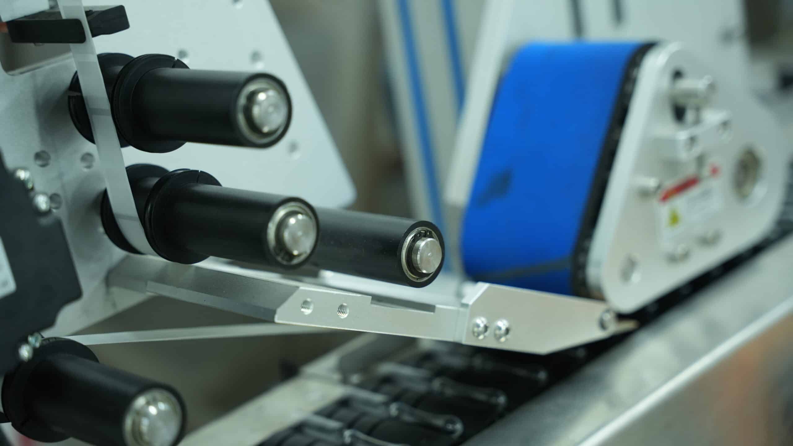 Applicator head of an automatic vial labeler machine for precise label application