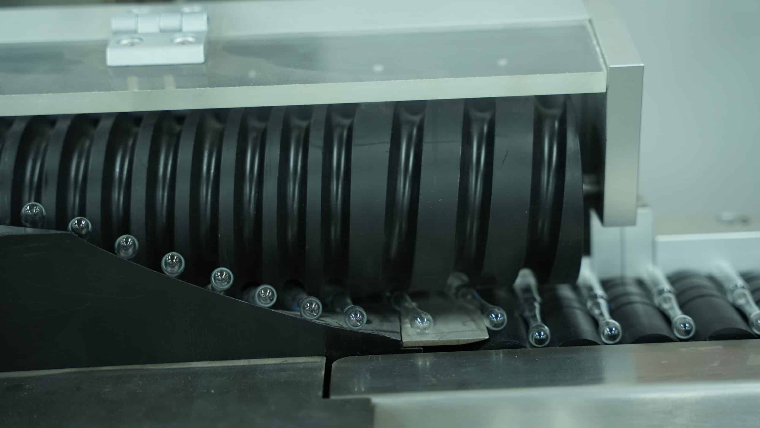 Material conveyor of an automatic vial labeler machine for stable vial conveying