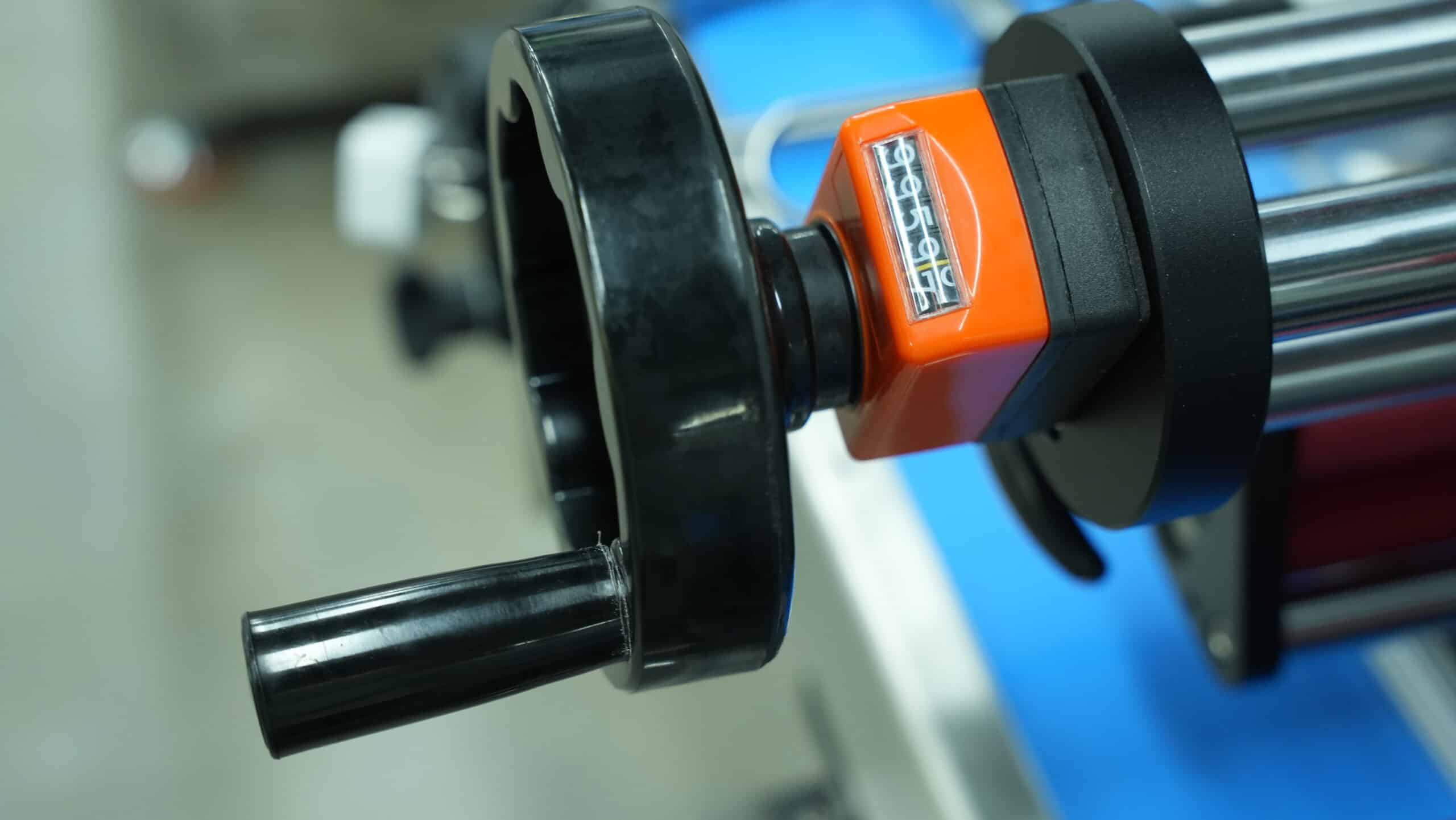 Roller adjustment mechanism of an automatic box labelling machine for stable and precise box positioning